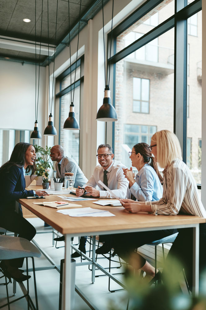 Smiling group of diverse businesspeople going over paperwork together